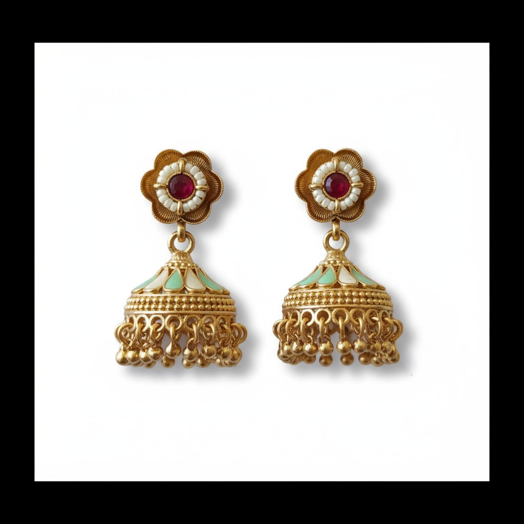 Gold earrings with red and green stones on a white background